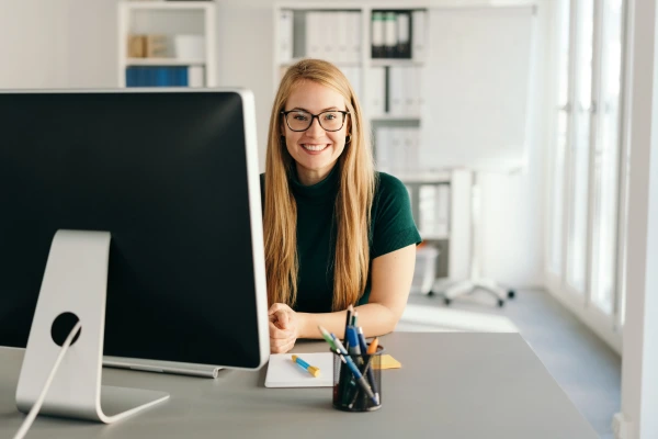 A woman smiling in front of a computer